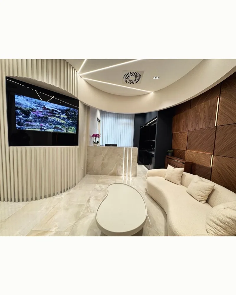The clinic waiting area: a low sofa, wood panelling and a screen on the wall.